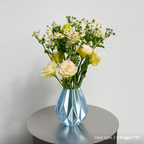 Bambu Lab PETG translucent filament displayed in decorative blue vase with yellow flowers and daisies